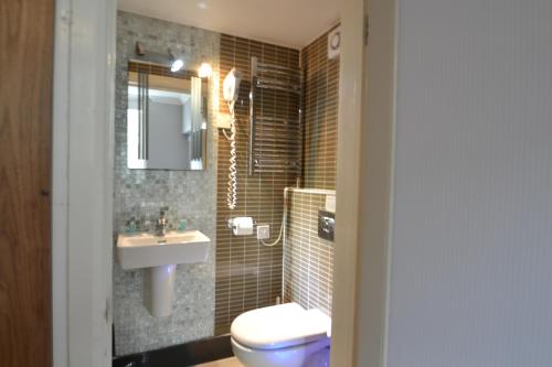 a bathroom with a toilet and a sink at Hyde Park Suites in London