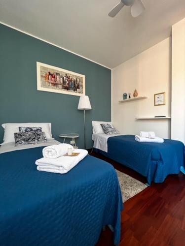 a room with two beds and a blue wall at Casanova Loc Turistica in Verona