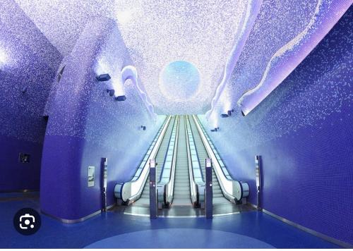 an escalator in a room with a purple ceiling at La casa di Sarah aspetta voi in Naples