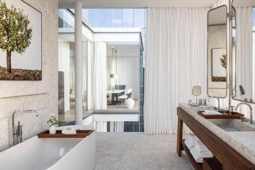 a bathroom with a tub and a large window at R48 Hotel and Garden in Tel Aviv