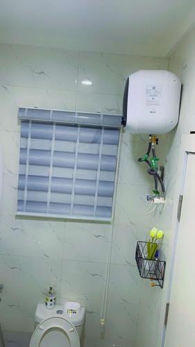 a bathroom with a white toilet and a window at Thistle Greens Apartment in Ikeja