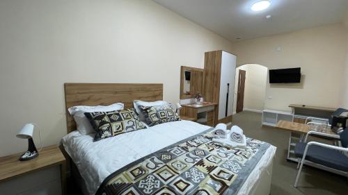 a bedroom with a large bed and a television at “Simbad” guest house in Jalal-Abad