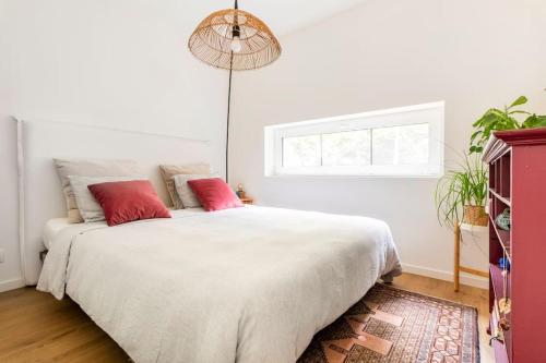 - une chambre avec un grand lit blanc et des oreillers rouges dans l'établissement Luxe-Avontuur in een Romantische Cabin in het Bos, à Stekene