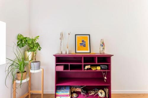 a purple book shelf withartments in a room with plants at Luxe-Avontuur in een Romantische Cabin in het Bos in Stekene