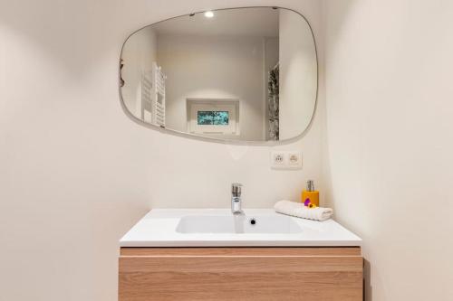 y baño con lavabo y espejo. en Luxe-Avontuur in een Romantische Cabin in het Bos, en Stekene