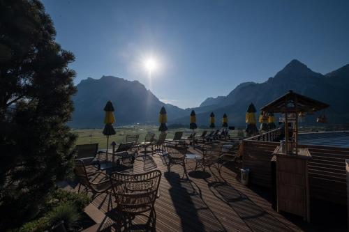 a group of chairs and umbrellas on a deck at Boutique Hotel Bellevue Lermoos in Lermoos
