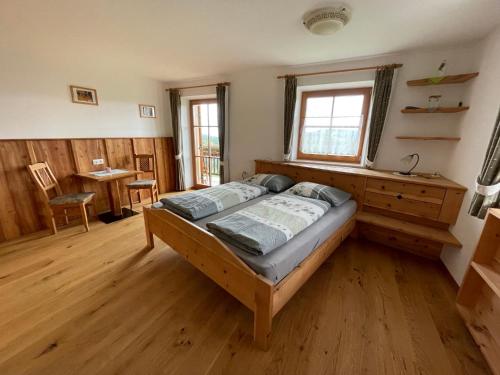 a bedroom with a bed and a wooden floor at Oberfahrerhof in San Genesio Atesino