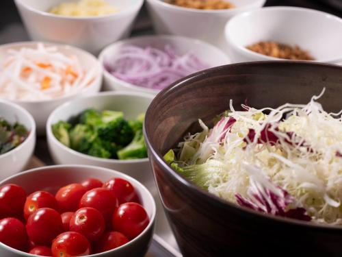 a table with bowls of different types of vegetables at HOTEL MYSTAYS Atsugi in Atsugi