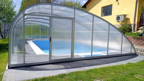 ein Gewächshaus aus Glas mit einem Pool darin in der Unterkunft Gourmetbauernhof Mentebauer in Gmünd in Kärnten