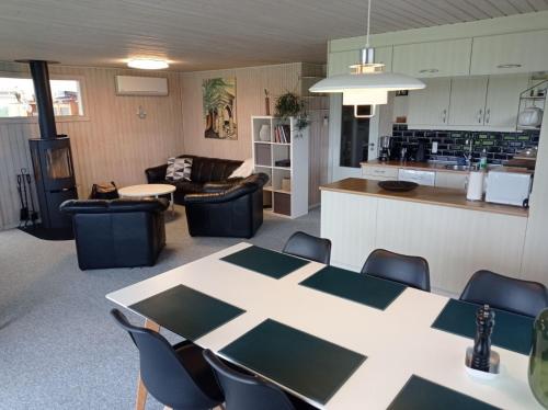 a room with a table and chairs and a kitchen at Øster Hurup in Hadsund