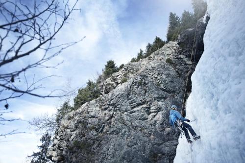 a man is climbing a rock formation on a mountain at Hotel Andy 4 Sterne Superior in Jerzens