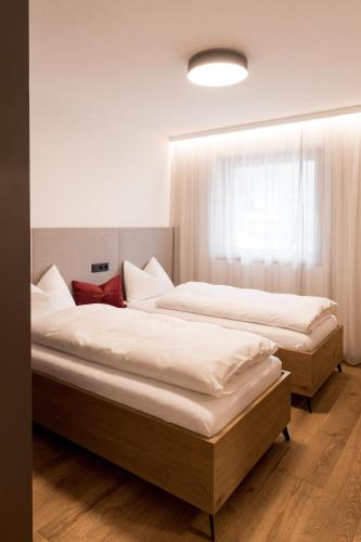 two beds in a bedroom with a window at Obergasserhof Apt Tiroler in Riscone