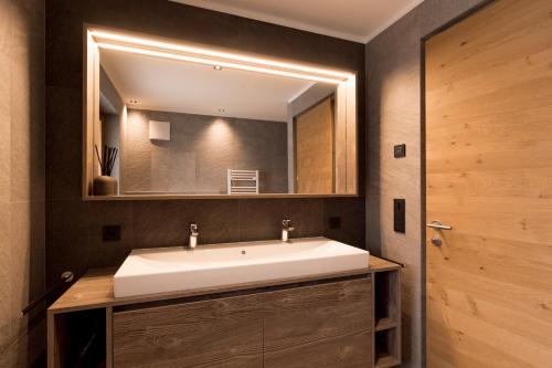 ein Badezimmer mit einem weißen Waschbecken und einem Spiegel in der Unterkunft Obergasserhof Apt Tiroler in Riscone