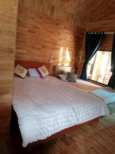 een slaapkamer met een groot wit bed en een raam bij Homestay thủy cường in Hòa Bình