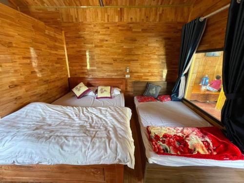 een kamer met 2 bedden in een houten hut bij Homestay thủy cường in Hòa Bình