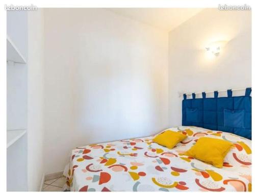 a white bedroom with a bed with yellow pillows at Appartement la Galerne Royan-Pontaillac - plage casino in Vaux-sur-Mer