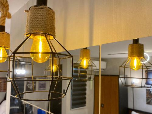 a group of three lights hanging from a mirror at Casa Cabilao Staycation in Santa Rosa