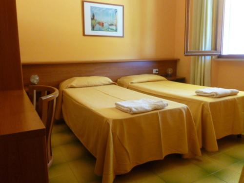 two beds in a hotel room with towels on them at B & B Summer in Marciana