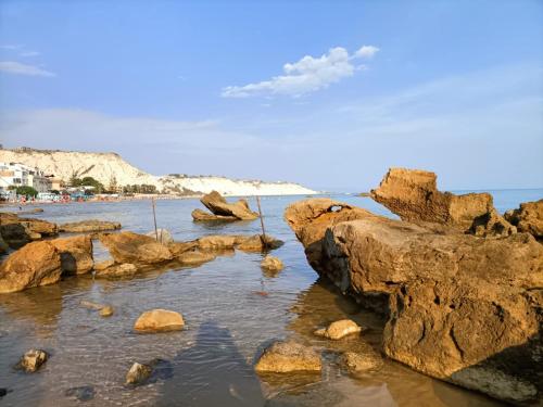 una spiaggia con rocce in acqua di Camere A Chiazza Realmonte a Realmonte