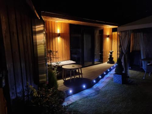 a patio with a table and lights on a house at The Chill in Shepton Mallet