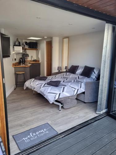 a bedroom with a large bed and a kitchen at The Chill in Shepton Mallet