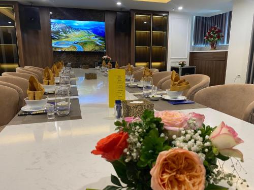 a conference room with a long table with flowers on it at Riverside Hotel Hà Nam in Phủ Lý