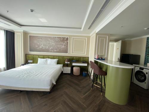 a bedroom with a large white bed and a kitchen at Riverside Hotel Hà Nam in Phủ Lý