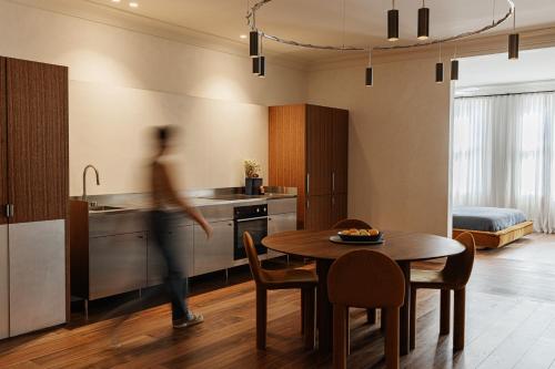 a person walking through a kitchen with a table at The Bercin in Sydney
