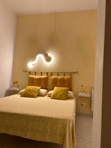 um quarto com uma cama com lençóis amarelos e luzes na parede em B&b regina del porto em Porto Empedocle