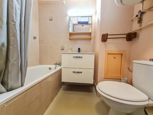 La salle de bains est pourvue de toilettes, d'une baignoire et d'un lavabo. dans l'établissement Y'Hôtes conciergerie - studio les habères 2/4 personnes, à Habère-Poche