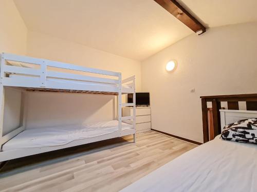 1 dormitorio con litera y 1 litera blanca en Y'Hôtes conciergerie - studio les habères 2/4 personnes, en Habère-Poche