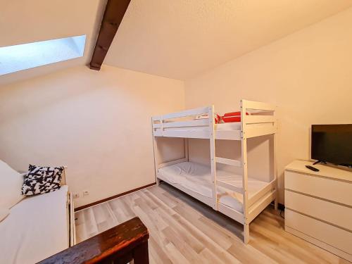a small room with a bunk bed and a television at Y'Hôtes conciergerie - studio les habères 2/4 personnes in Habère-Poche