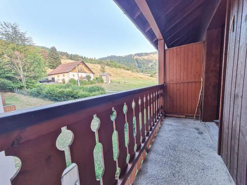 d'un balcon avec une clôture offrant une vue sur une maison. dans l'établissement Y'Hôtes conciergerie - studio les habères 2/4 personnes, à Habère-Poche