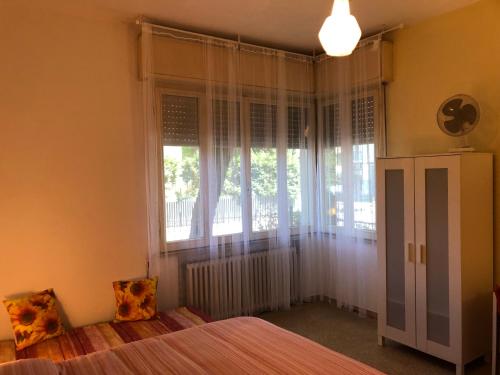 a bedroom with a bed and a large window at Struttura Alloggio Fabrizio Rimini in Rimini