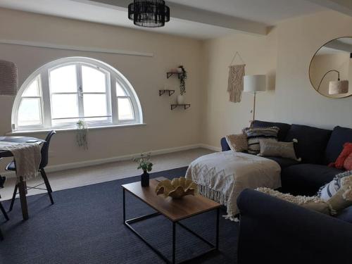 ein Wohnzimmer mit einem Sofa und einem Tisch in der Unterkunft Two Bed Flat Sea view Old town Hastings in Hastings