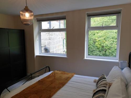 ein Schlafzimmer mit 2 Fenstern, einem Bett und einem TV in der Unterkunft Two Bed Flat Sea view Old town Hastings in Hastings