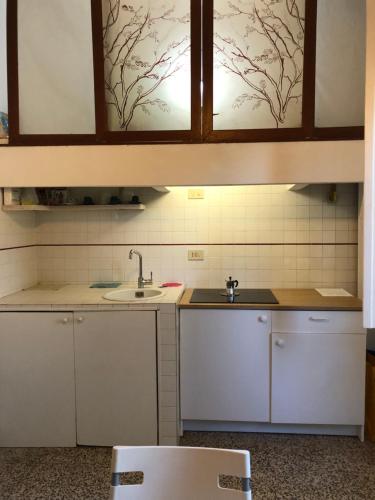 a kitchen with white cabinets and a sink at Struttura Alloggio Fabrizio Rimini in Rimini