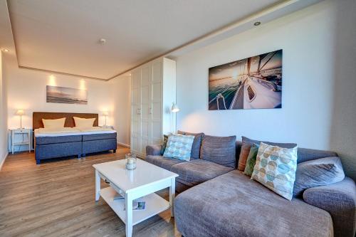 a living room with a couch and a bed at Berolina Wohnung 300 in Dahme