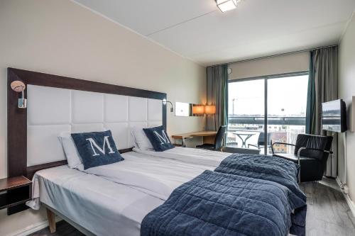 um quarto de hotel com uma cama grande e uma janela em Quality Hotel Maritim em Haugesund