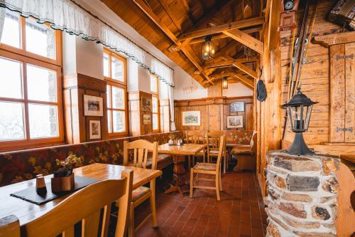 a restaurant with wooden walls and tables and windows at Fichtelberghaus in Kurort Oberwiesenthal