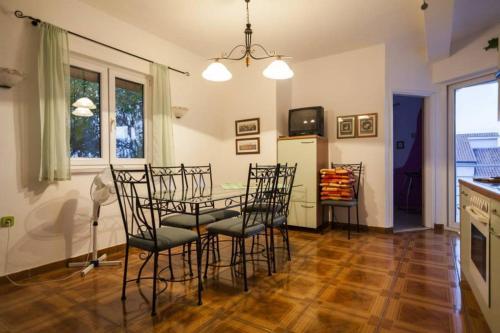 a room with a table and chairs and a kitchen at Holiday Home Drescher in Murter