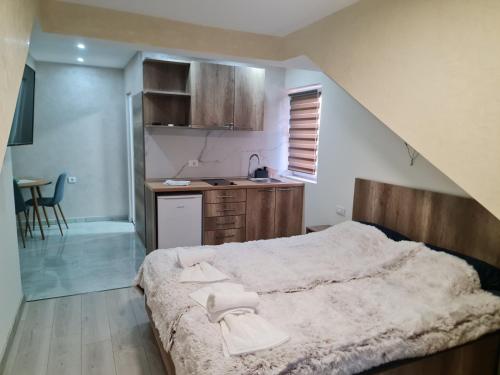 a bedroom with a large bed and a kitchen at Apartman LANA 2023 in Arandjelovac