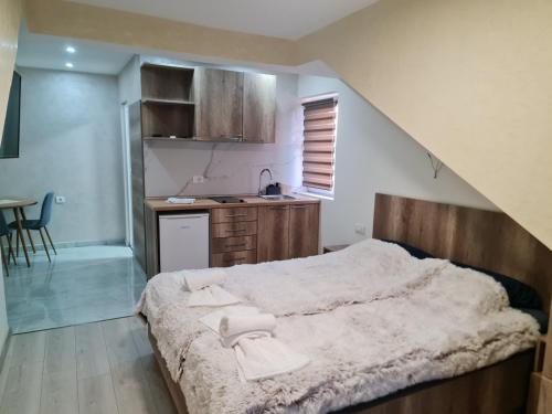 a bedroom with a large bed and a kitchen at Apartman LANA 2023 in Arandjelovac