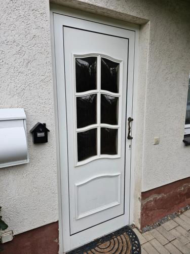 eine weiße Tür mit Fenster auf einem Haus in der Unterkunft Ferienwohnung Kehrer in Schwarzenberg