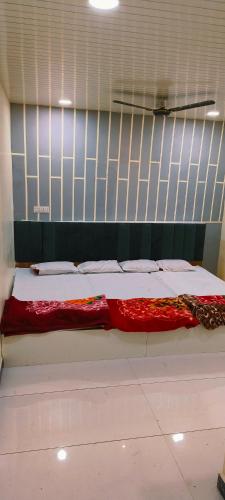 Una cama con una manta roja y blanca. en Hotel shree Gajanand palace, en Ujjain