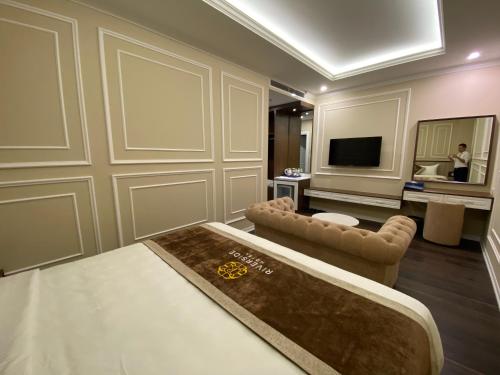 a living room with a couch and a television at Riverside Hotel Hà Nam in Phủ Lý