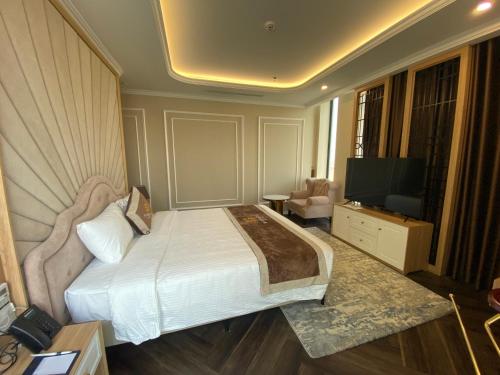 a hotel room with a bed and a television at Riverside Hotel Hà Nam in Phủ Lý