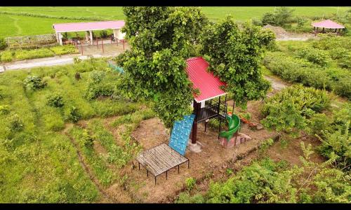 an overhead view of a playground with a tree at The GreyStone FarmHouse, Turibari in Ranīchera
