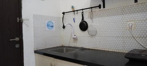 a kitchen with a sink and utensils on the wall at Griya Mas The Jarrdin in Bandung