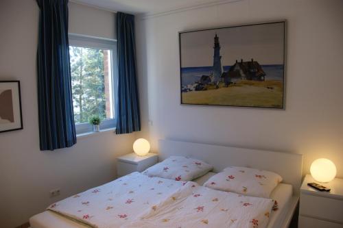 ein Schlafzimmer mit einem Bett und zwei Fenstern in der Unterkunft Blaue Perle Wohnung Nr 16-3 in Schönberger Strand